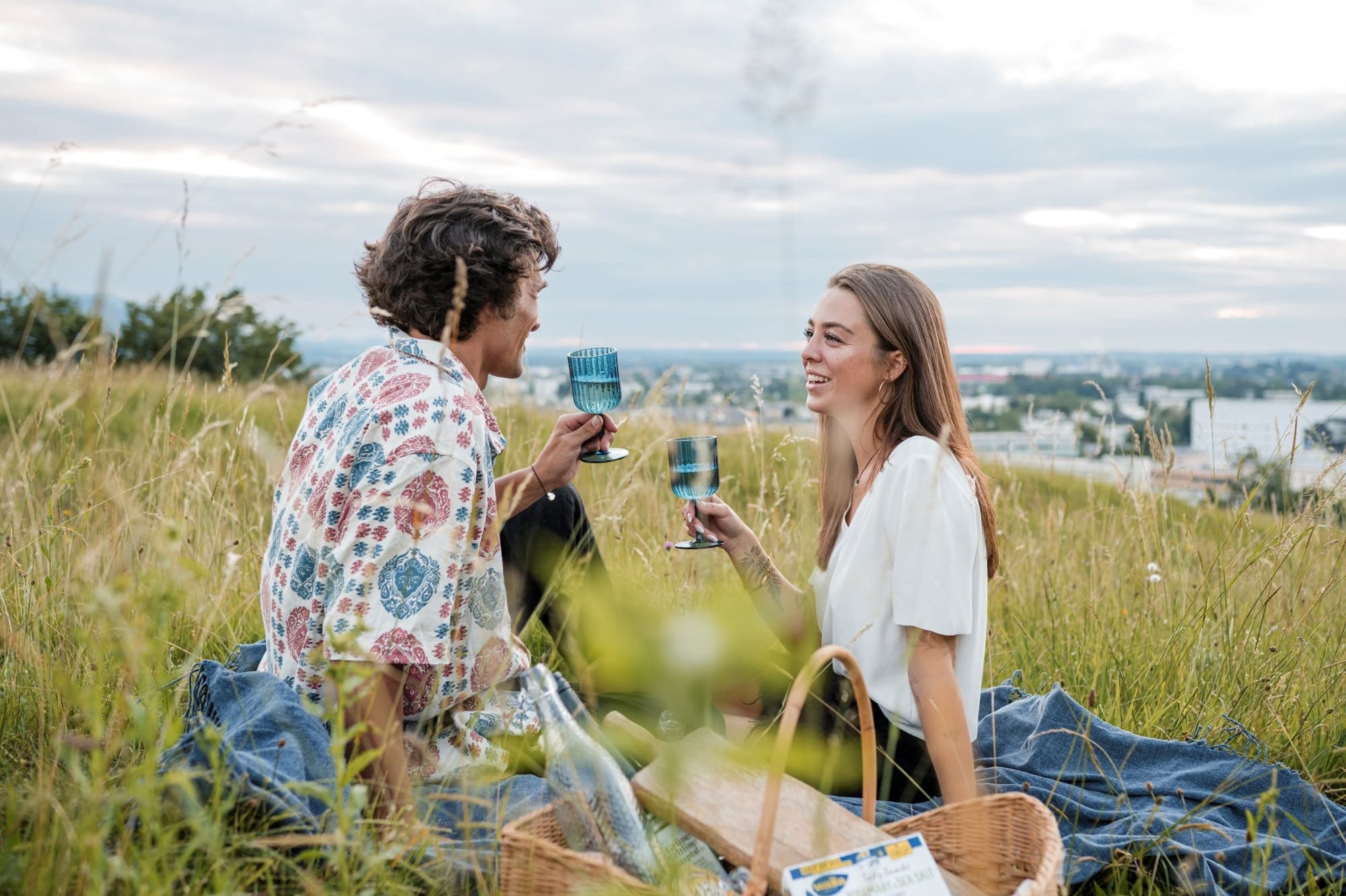 Picknick mit Ausblick auf die Stadt Salzburg, umgeben von grünen Wiesen und der historischen Skyline im Hintergrund © Lorenz Masser