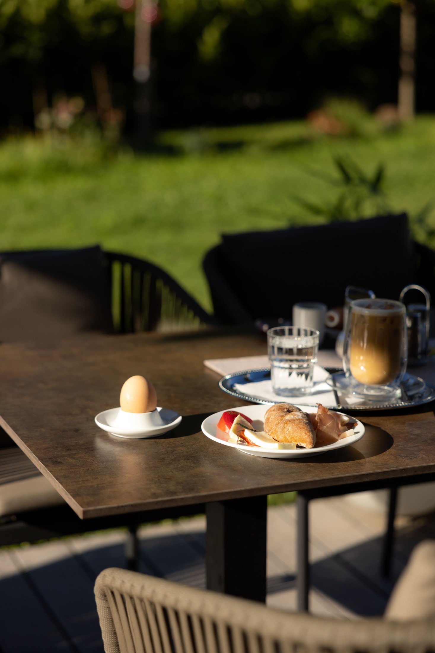 Frühstückstisch im Garten mit Croissants und Kaffee.